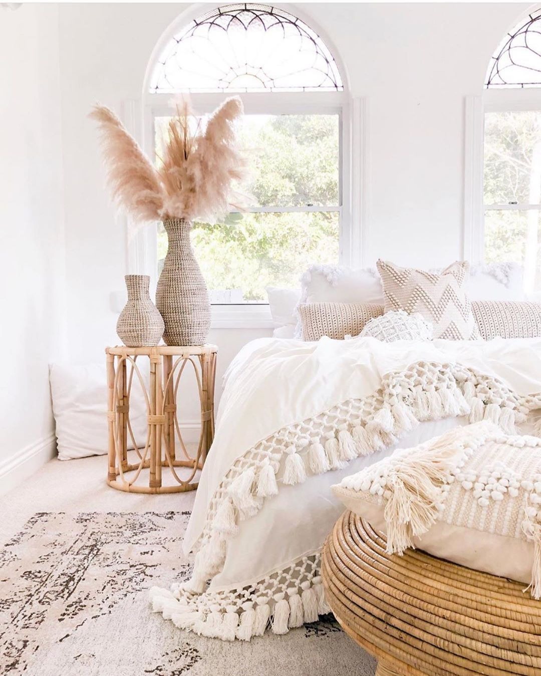 pampas grass dried flower arrangements sitting on a bedside table by a window